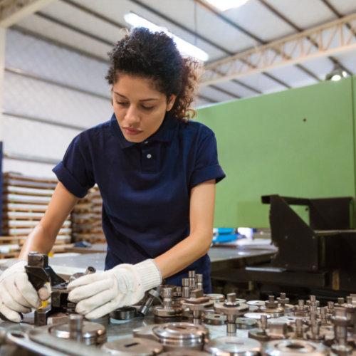 3 young woman assembling machine parts